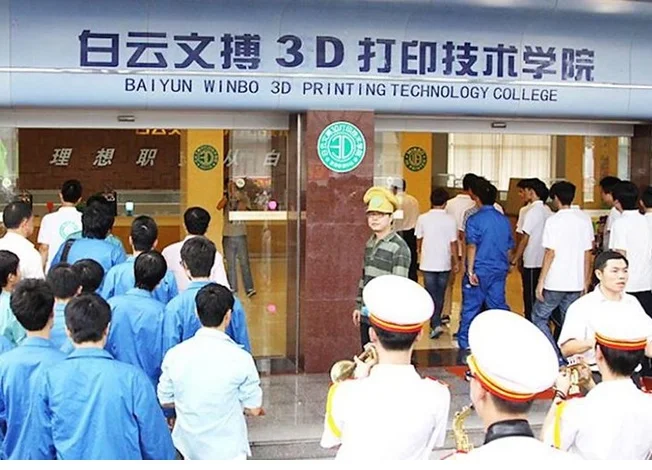 Студенты в униформе перед зданием колледжа 3D-печати Baiyun Winbo.