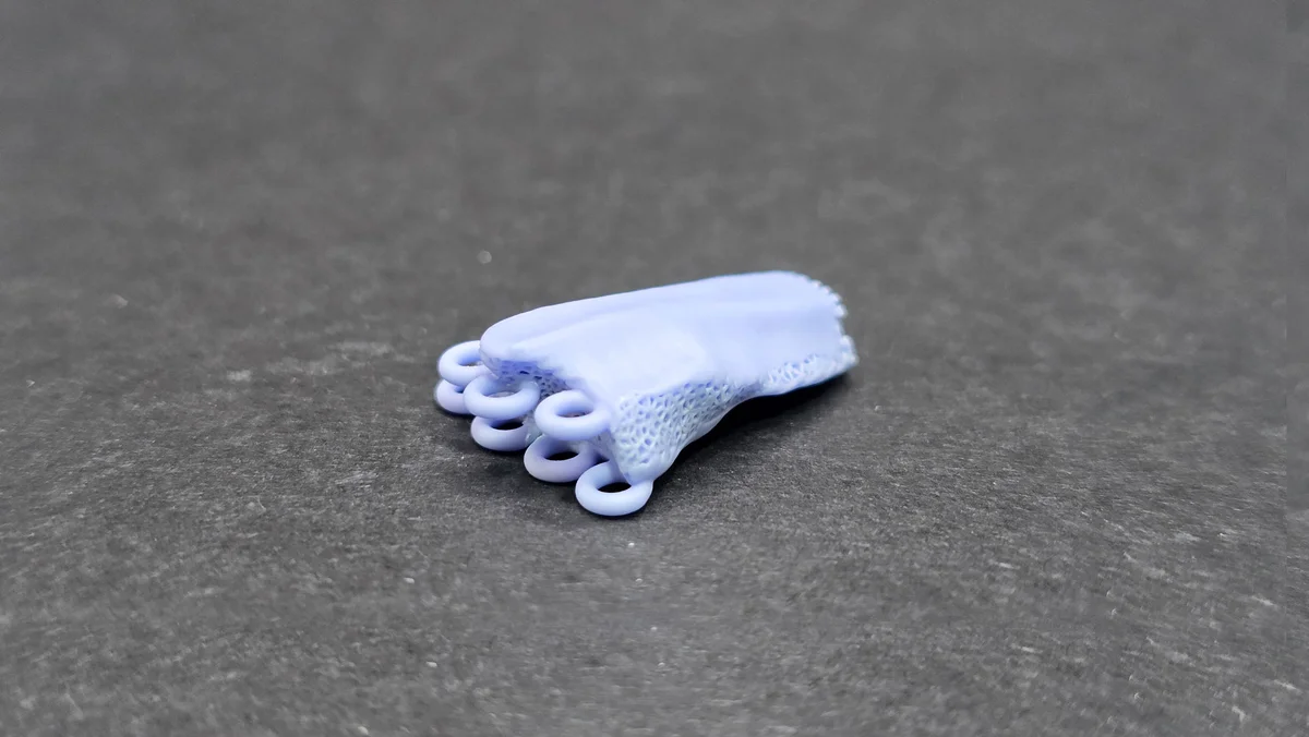 Светло-голубая 3D-печатная биокерамическая деталь с пористой структурой и кольцевыми выступами