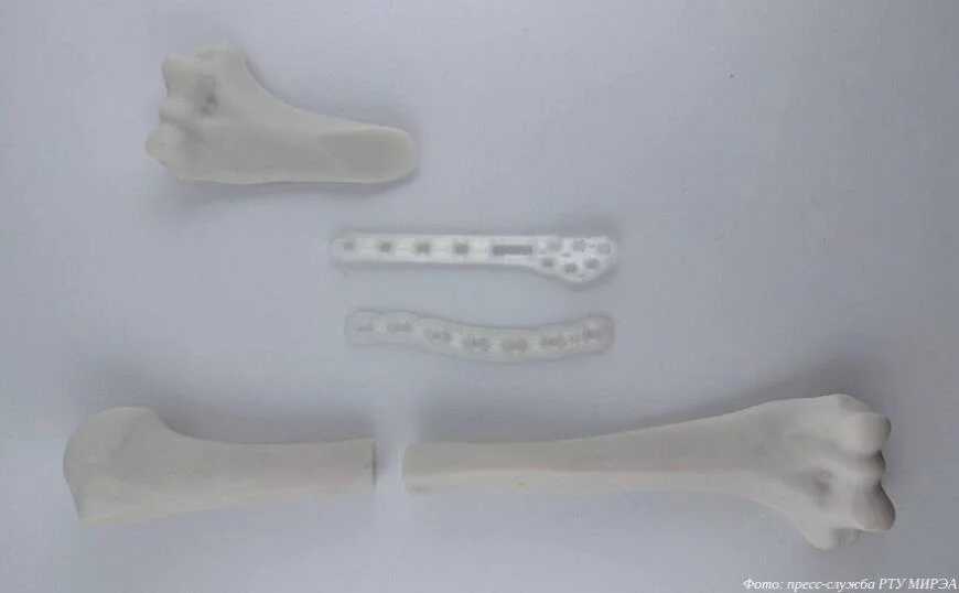 Три 3D-печатных биоразлагаемых костных имплантата и две части трубчатой кости, подготовленные для соединения.